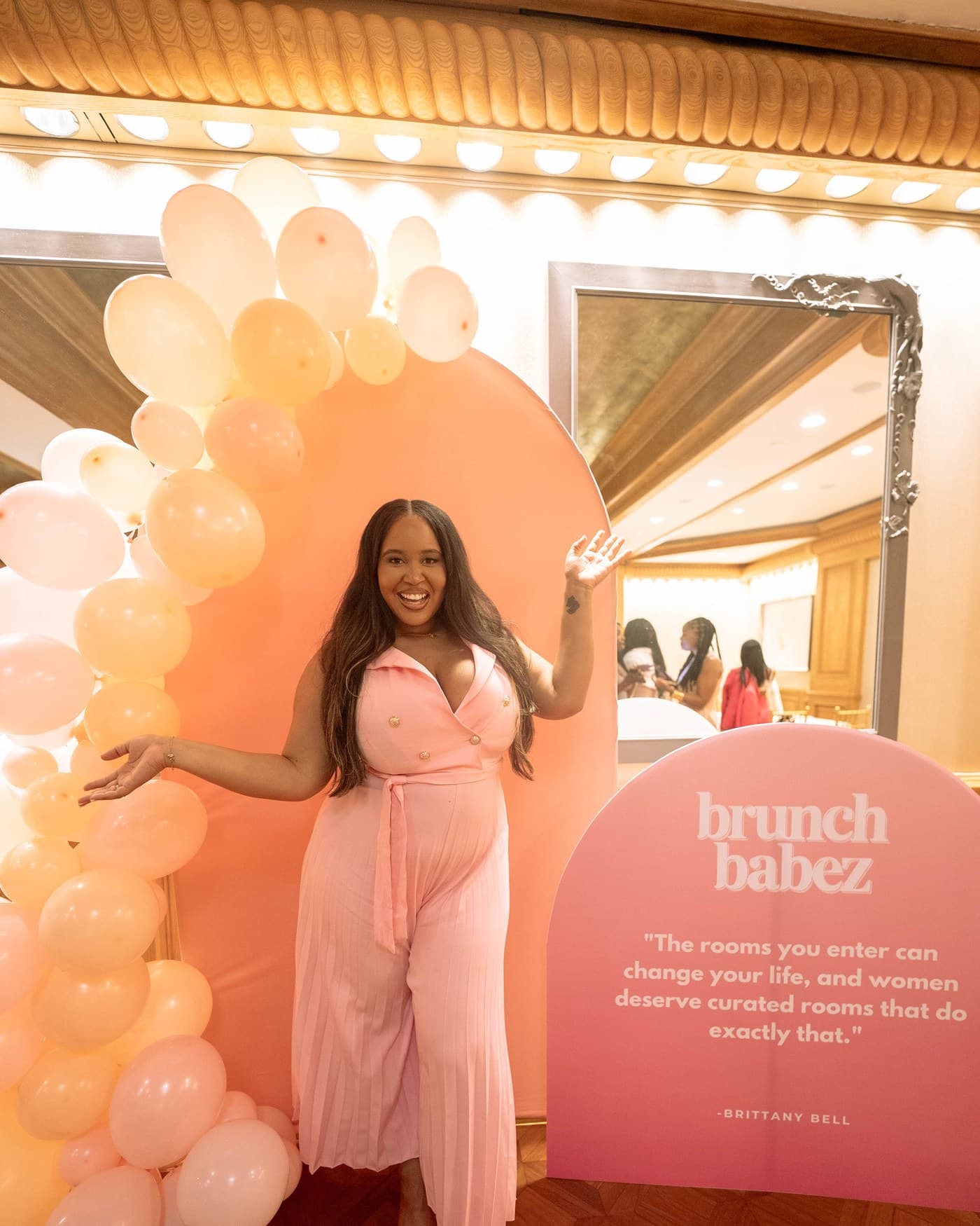 A guest at the balloon installation beside the Brunch Babez board.