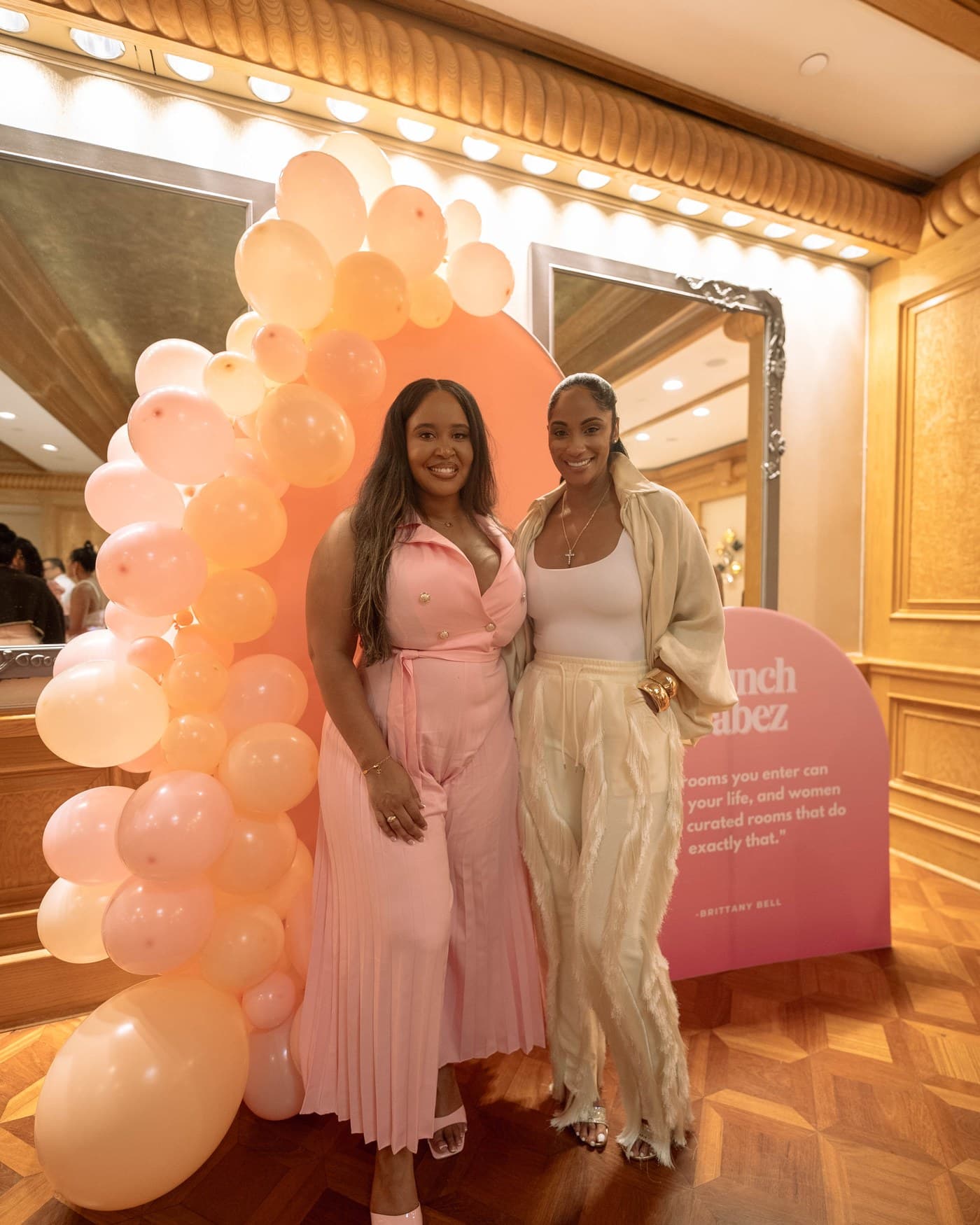 Two guests photographed at the Brunch Babez balloon arch.
